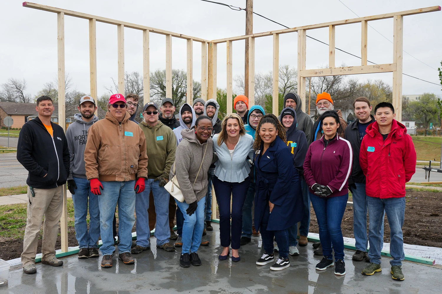 Textron Aviation workers smiling for a group photo with Wichita Habitat employees and family partner.