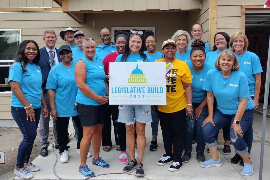 Participants attending Legislative Build 2023 taking a group photo with a Legislative Build 2023 sign.