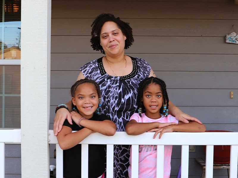 A Habitat family standing on their porch.